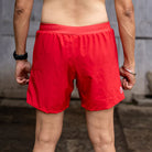 A male model wearing Apace men's 5-inch running shorts in black, showcasing the lightweight and breathable athletic shorts.