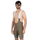 Apace men's cycling endurance bib shorts in moss green, featuring padded chamois and adjustable straps for comfortable riding.