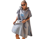 Azen unisex lightweight microfiber hooded beach towel with orange and blue stripes, shown draped over a person on the beach.
