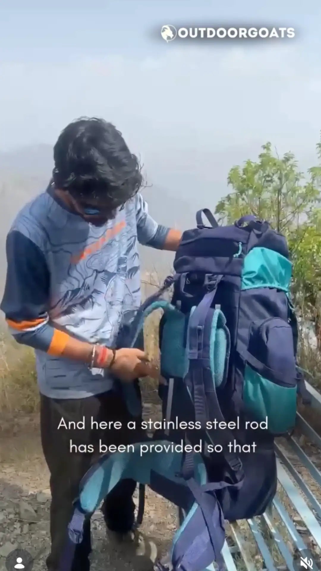 Dark blue and teal hiking backpack with adjustable straps and a stainless steel rod attached to the side.