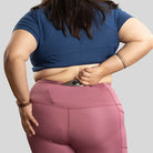 Ruggd Indian women's all-in-one training leggings in vibrant orange color, shown on a model for active workout wear.